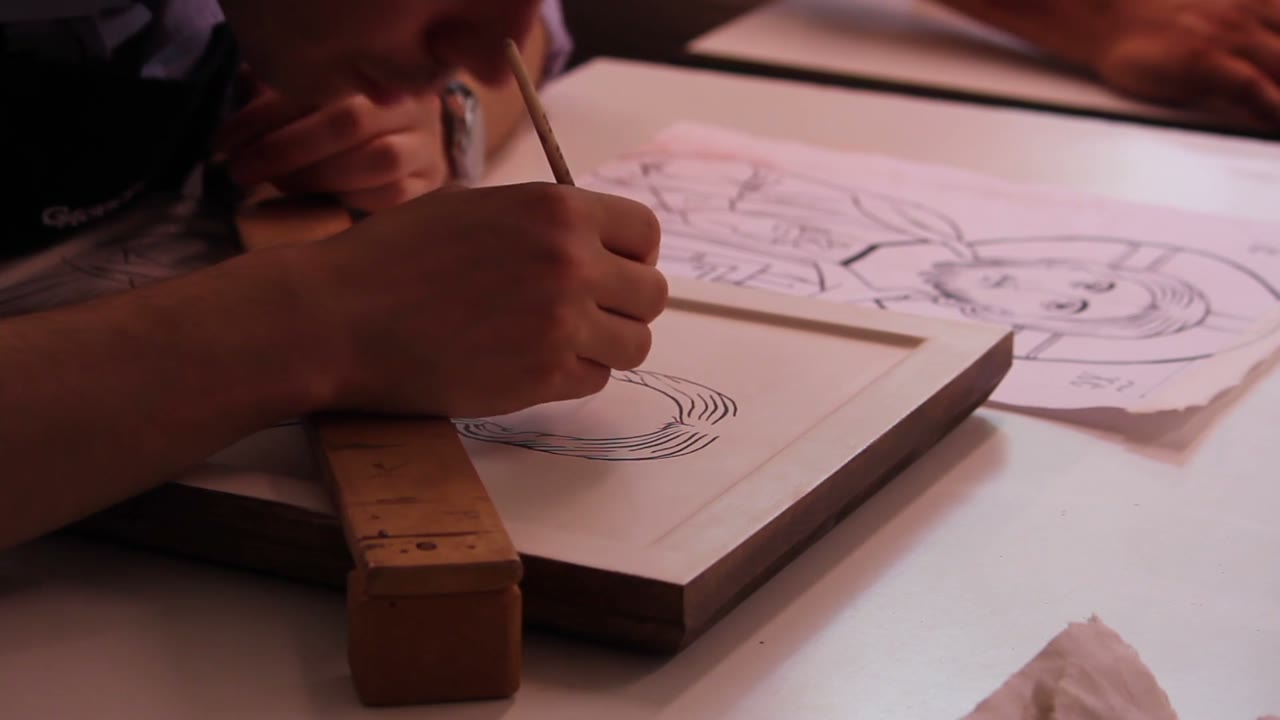 Disegno di un volto sulla tavola, con il modello accanto